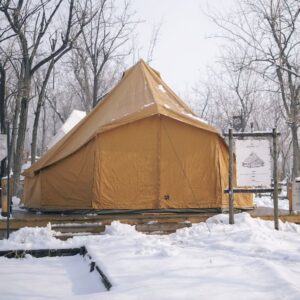 Autentic | Luxury Glamping Bell Tents - A turmeric Autentic bell tent covered in snow at Hillands Glamping in China